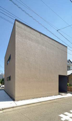 洞窟のようなテクスチャーの外壁に、スクエア型のシンプルな外観