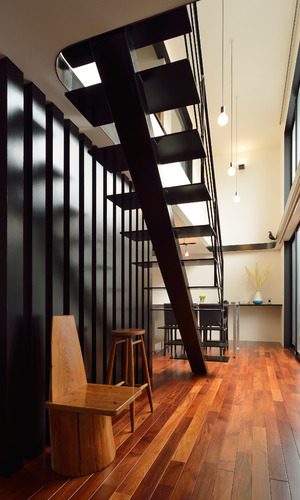 美しいフォルムの階段下はまるで椅子のギャラリーのよう