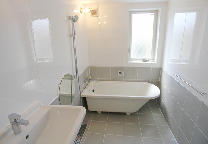 丸い鏡が印象的な浴室