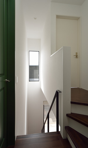 白、緑、焦げ茶のカラーバランスが絶妙な吹抜けの階段