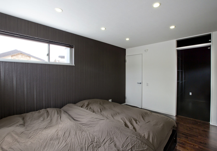 白と焦げ茶で統一され、落ち着きのある寝室