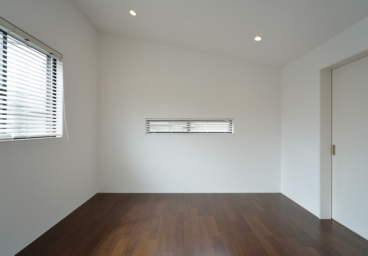 広がりのある勾配天井のシンプルな寝室