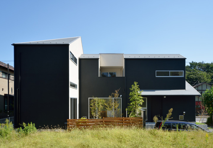 白い物体を黒で包み込んだような配色のモダンな家