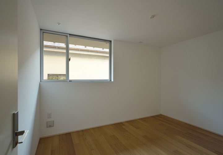 隣地との高低差を考慮しながら窓を配置した寝室