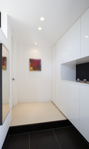 白黒の空間に赤い絵が差し色になっている玄関