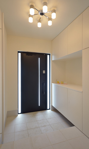 玄関ドア横スリットから入る光が、白をメインに広々とした空間に映える