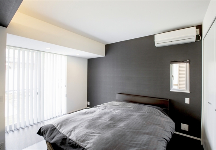 黒い壁がアクセントの寝室