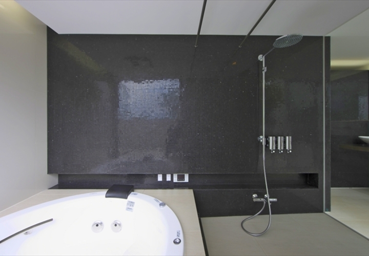 黒いタイルが印象的な浴室