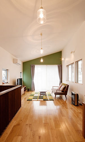 深緑の壁と勾配天井で広く感じるLDK