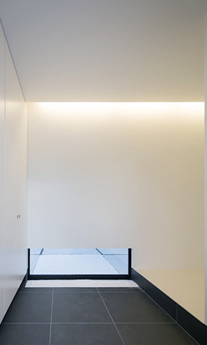 ローサイドライトが外の気配を感じさせる玄関