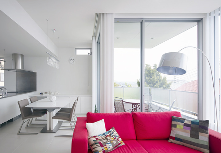 白を基調とした室内に映えるビビットカラーのソファ