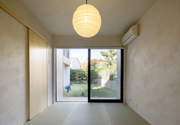 大きく開いた和室窓から中庭を眺める