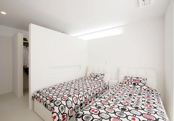 ベッドカバーがアクセントの落ち着いた寝室