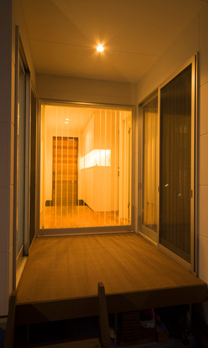 玄関から繋がる夜のウッドデッキ