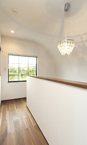 白壁に映るシャンデリアの影が優しい廊下