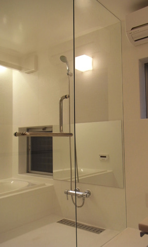 浴室扉と仕切りをガラスにし、洗面ルームと一体化して見えるバスルーム