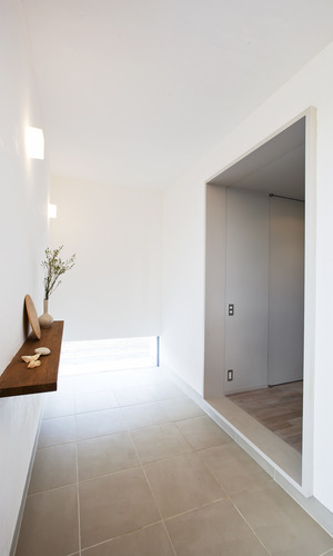 玄関とは思えない、漆喰で塗られたニュートラルな玄関空間