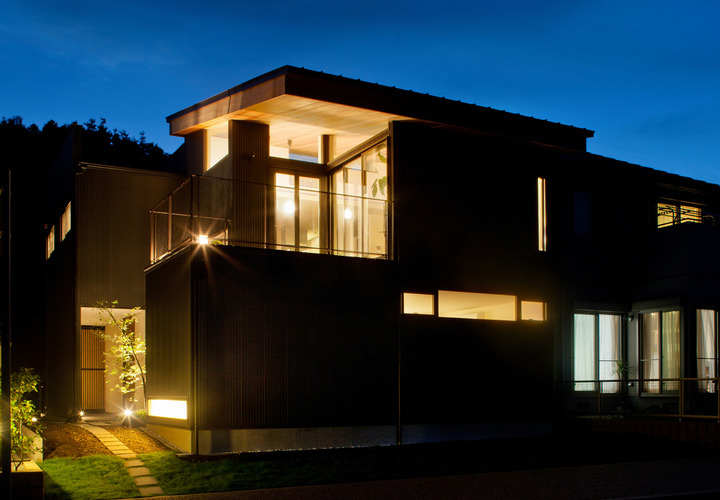 森をバックに、癒される光が心地よい夜の外観