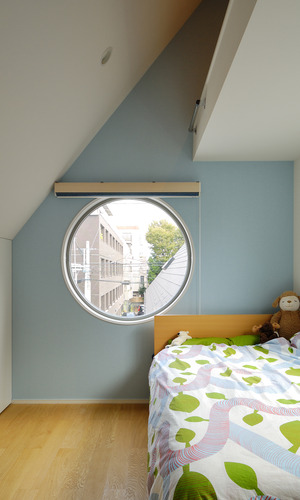 パステルブルーの壁に大きな丸窓が、まるで秘密基地のような子供部屋