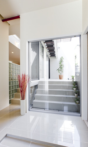 敷地の高低差を利用した階段・天井の高さが、上下方向にリズムのあるデザインに活かされた玄関スペース