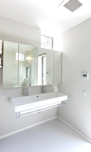 高窓から、ほど良い光と中庭の緑を見ることができる清潔感ある洗面所