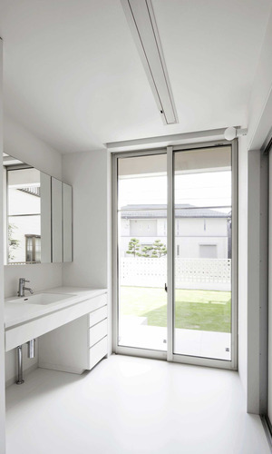中庭を見ながら身支度ができる、明るく開放的な白一色の洗面脱衣室