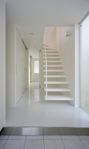 大きな窓を設け、床を光沢な素材にすることで明るい印象の玄関ホール