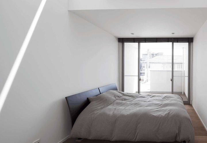 ハイサイドライトから光が差し込む、プライベートバルコニーを持つ主寝室