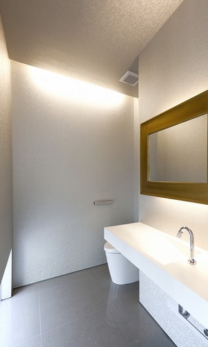 シルバーのクロスとゴールドのミラーの対比が、非日常的な空間を生み出しているトイレ