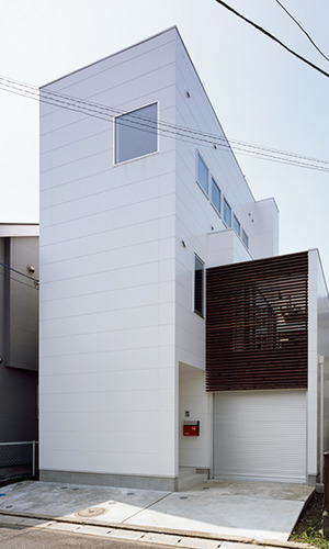 白い外壁に木の格子が美しい外観