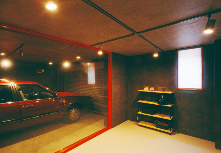 赤の建具が印象的なガレージを望む部屋