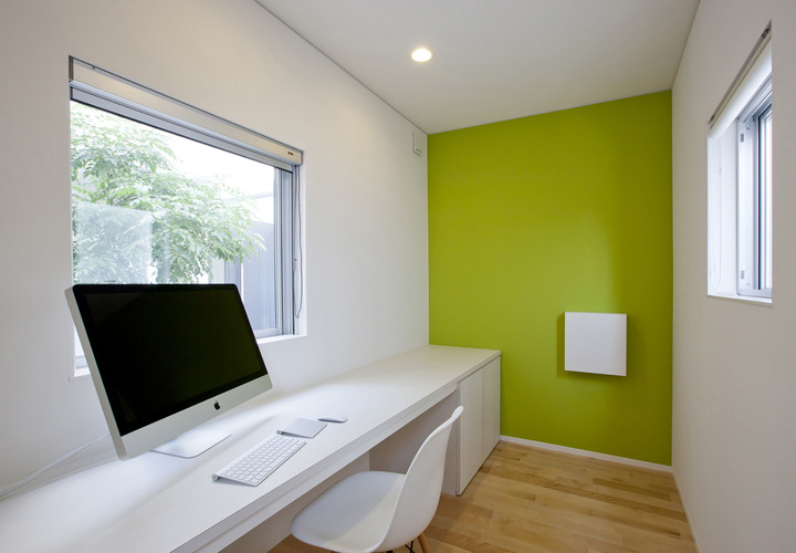 中庭向かう開口を伴う書斎机と、アクセントの壁との配色が素敵な書斎