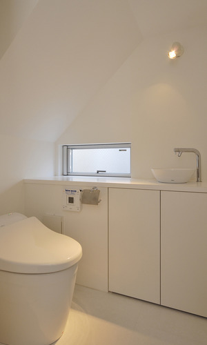 スポットライトの明かりを利用し空間に重点を置いた、隠れ家のような落ち着きのあるトイレ