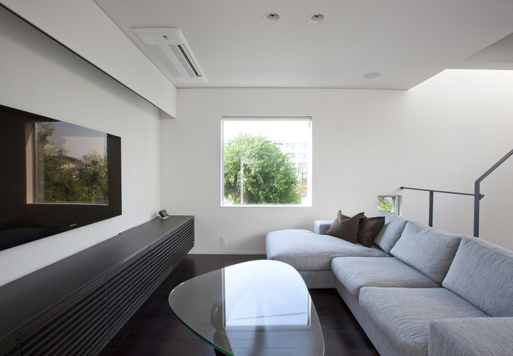 ピクチャーウインドウには、借景の常緑樹が豊かな時間を提供してくれるリビング