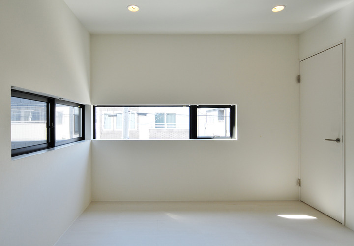 水平に切り取られた窓から朝日が入り込み、独特の朝を迎えられる寝室