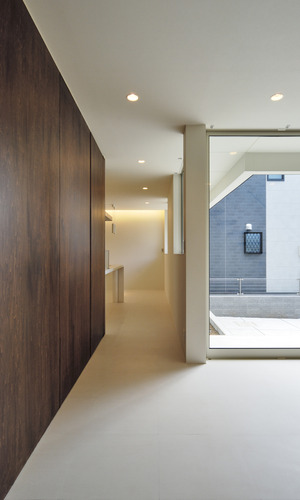 壁一面を使用した、天井高まである茶色に塗ったシナ合板貼り収納壁