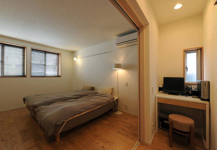無駄を省いた空間利用方法をした廊下に面した机と、可変性を持った主寝室