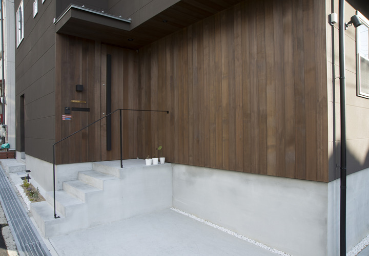外観の角部分は木板貼りとし、玄関ドアが分からないようなデザインの玄関