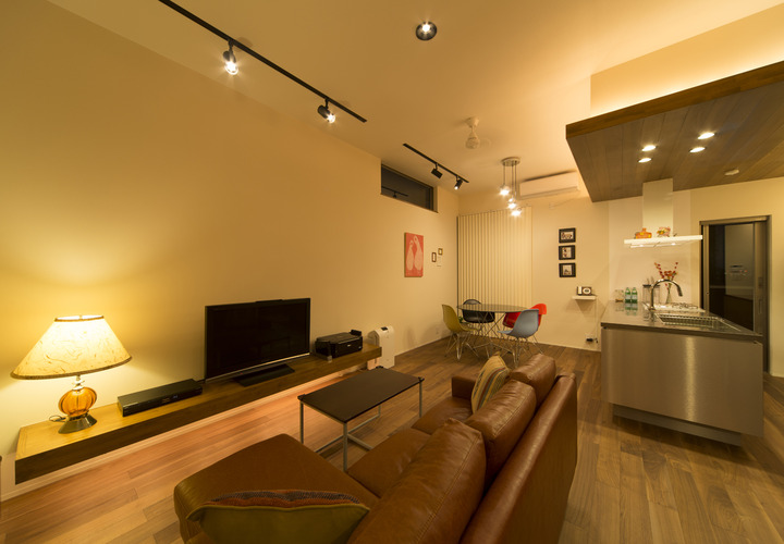 茶色でまとめたフローリング・造作家具と茶色の革張りソファが、こだわりの強さを感じる美的センスが高いLDK