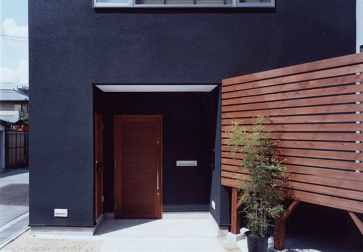 黒い壁に木目が映える玄関アプローチ