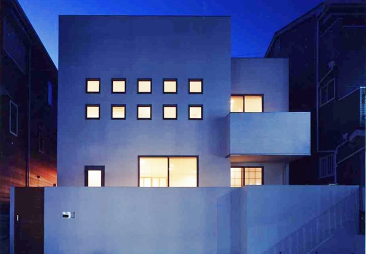 正方形の窓にライトが灯る夕景