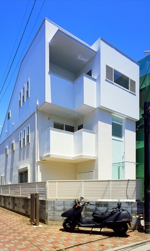 白が空に映えるモダンな外観