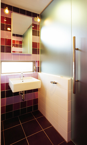 パープルのタイルが印象的な洗面スペース