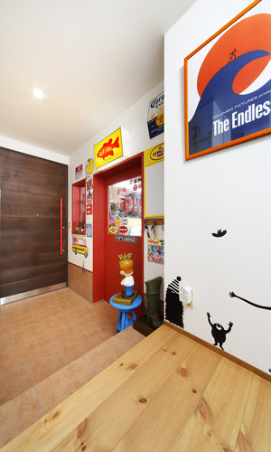 赤いドアとカラフルな雑貨が、楽しさをいっぱいにする玄関ホール