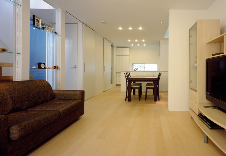 規則正しく並ぶダウンライトが、白木のフローリングと白壁に柔らかい光を当てるＬＤＫ