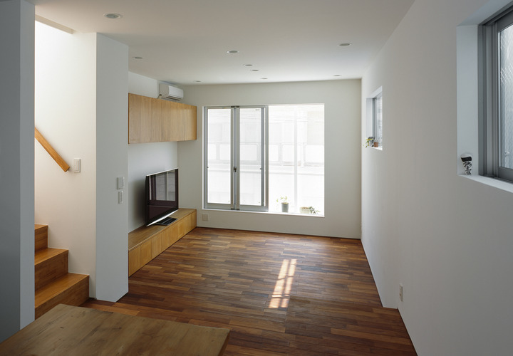 横手に引き詰めたフローリング材が、細長い空間に横の広さも感じさせるリビング・ダイニング