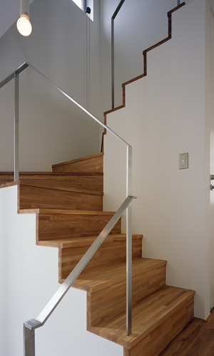 ステンレスヘアライン仕上げの手すりと集成材が、シンプルで上品な階段まわり