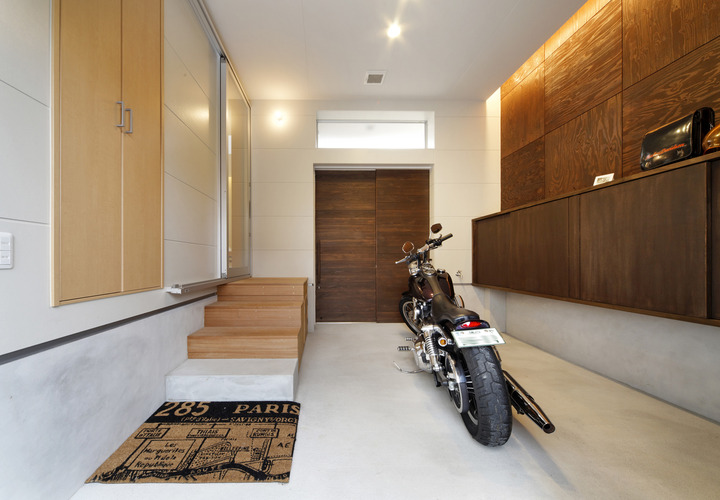 基礎のモルタルを高めにして土間の役割を持たせた、趣味のバイクの車庫兼玄関