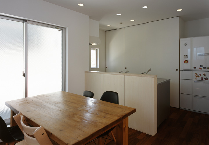 システムキッチンに腰壁を付け、ローコストでシンプルにまとめた対面キッチン