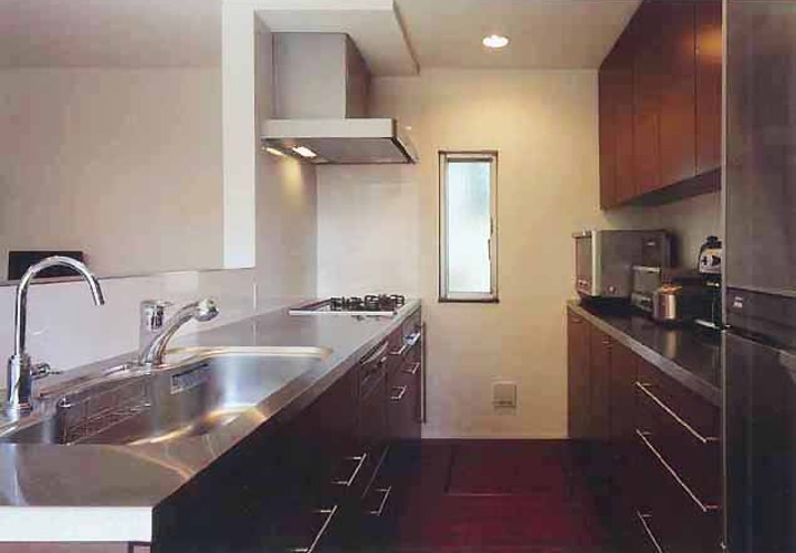 ステンレス素材と焦げ茶の木目で統一した、清潔感あるキッチン